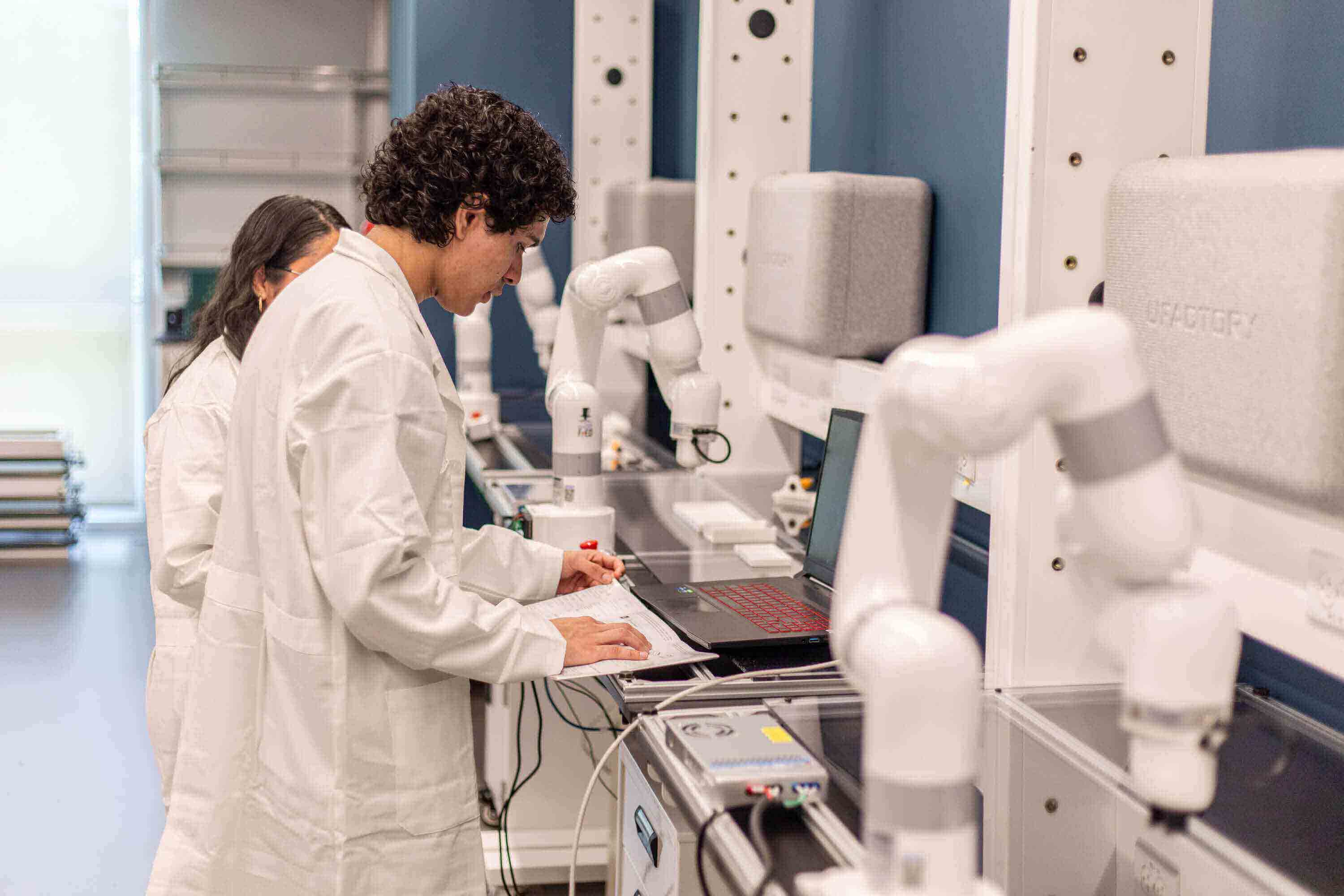 Estudiantes trabajando con cobots
